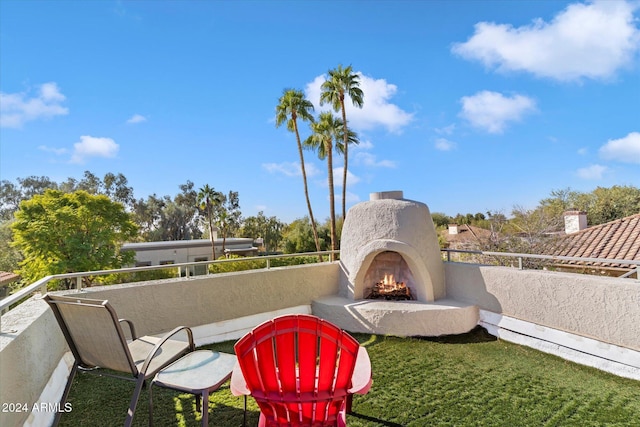 view of patio / terrace with a balcony and an outdoor fireplace