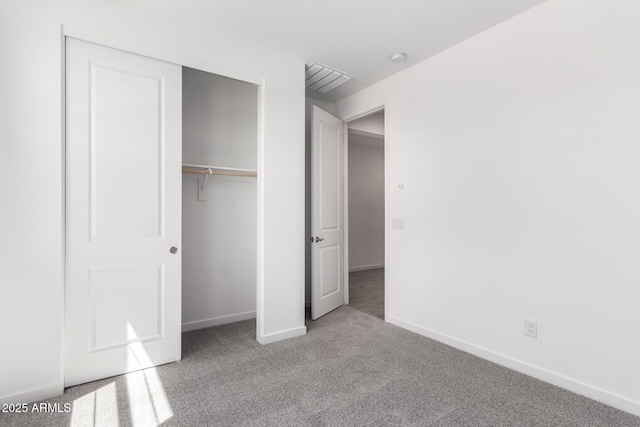 unfurnished bedroom featuring a closet, baseboards, and carpet