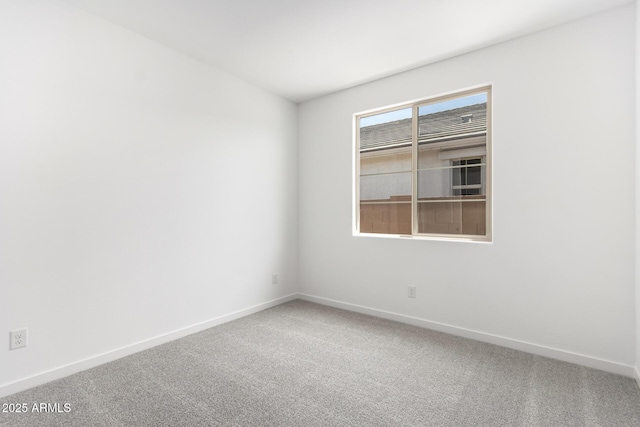 spare room with carpet and baseboards