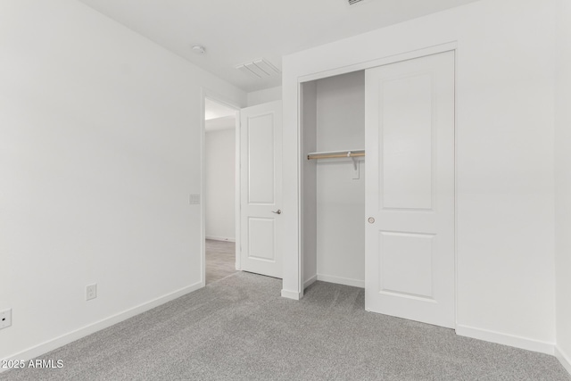 unfurnished bedroom featuring a closet, visible vents, baseboards, and carpet floors
