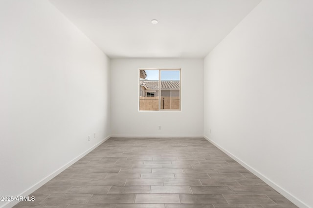 empty room with baseboards and wood finished floors