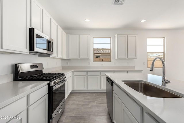 kitchen featuring light countertops, appliances with stainless steel finishes, a sink, and visible vents