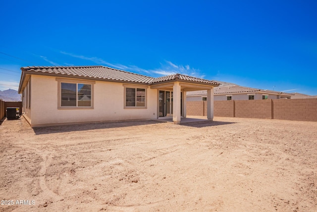 back of property featuring stucco siding, a patio area, a fenced backyard, central AC, and a tiled roof