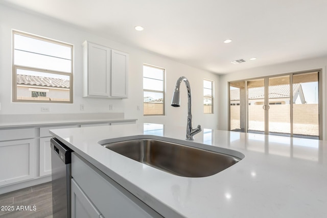 kitchen with recessed lighting, light countertops, visible vents, stainless steel dishwasher, and a sink