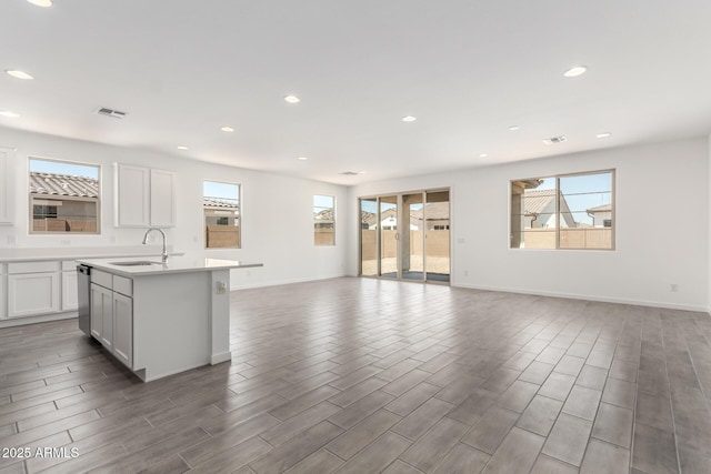 kitchen featuring a wealth of natural light, open floor plan, a center island with sink, and a sink