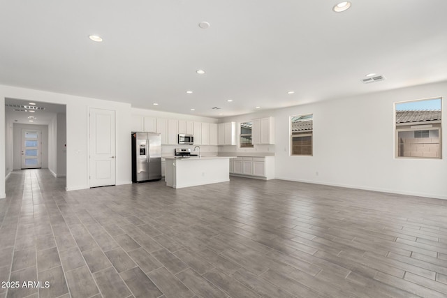 unfurnished living room with visible vents, recessed lighting, and plenty of natural light