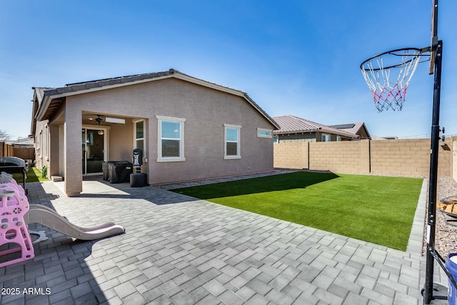 rear view of house featuring a yard, a patio, and ceiling fan