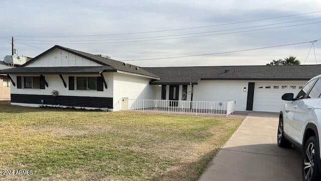 ranch-style house featuring a garage and a front yard