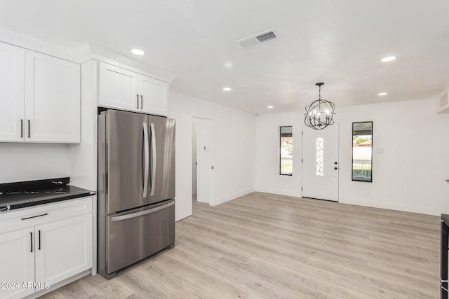 kitchen with stainless steel refrigerator, white cabinetry, a chandelier, and light wood-type flooring