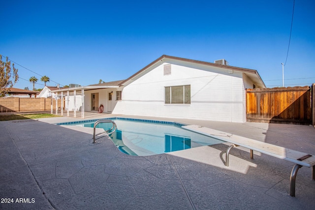 view of pool featuring a diving board and a patio area