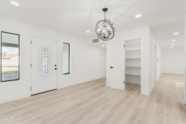 foyer with light hardwood / wood-style floors and a notable chandelier