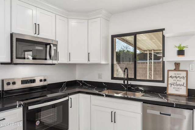 kitchen featuring white cabinetry, sink, appliances with stainless steel finishes, and dark stone counters