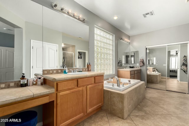 bathroom with visible vents, a garden tub, a stall shower, a sink, and tile patterned flooring