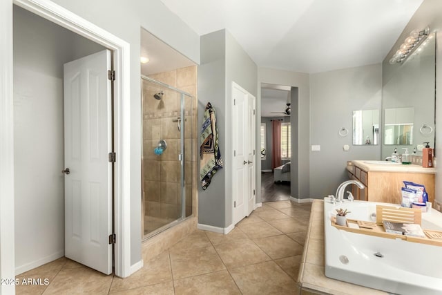 ensuite bathroom with tile patterned floors, connected bathroom, a shower stall, baseboards, and vanity