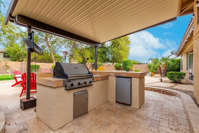 view of patio featuring grilling area, an outdoor kitchen, and a fenced backyard