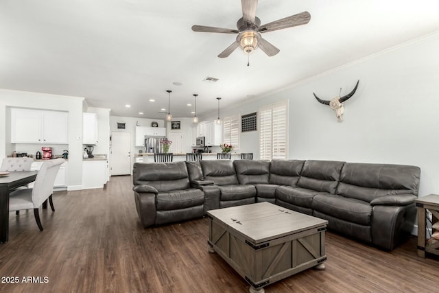 living room with dark wood-type flooring, crown molding, and visible vents