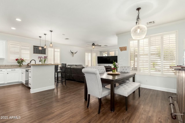 dining area with dark wood finished floors, crown molding, baseboards, and a wealth of natural light