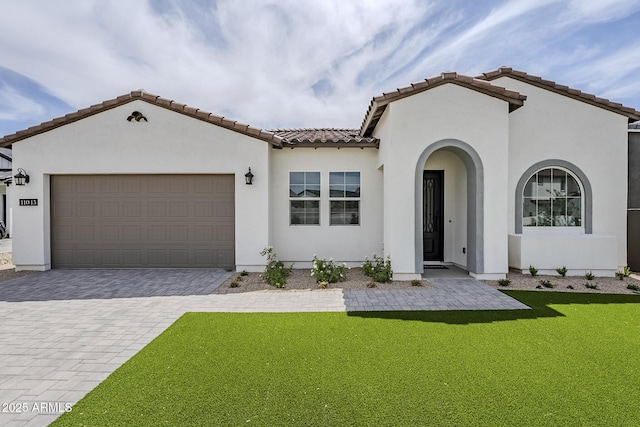 11045 N Hershey St, Surprise, AZ 85388 - mediterranean / spanish house featuring stucco siding, decorative driveway, a garage, a front yard, and a tile roof