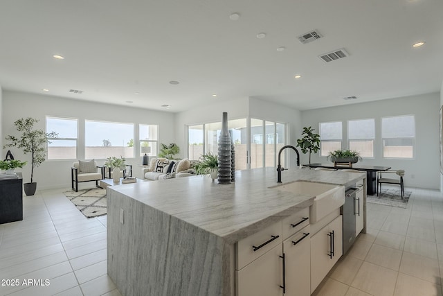 11045 N Hershey St, Surprise, AZ 85388 - kitchen with a sink, recessed lighting, light stone counters, a kitchen island with sink, and baseboards
