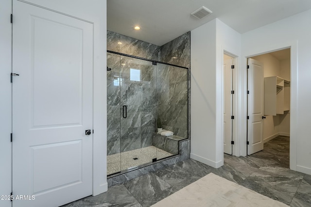 11045 N Hershey St, Surprise, AZ 85388 - full bathroom with marble tiled floors, baseboards, a marble finish shower, a walk in closet, and recessed lighting