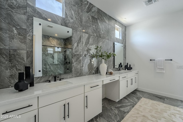 11045 N Hershey St, Surprise, AZ 85388 - bathroom featuring double vanity, a marble finish shower, marble finish flooring, and baseboards