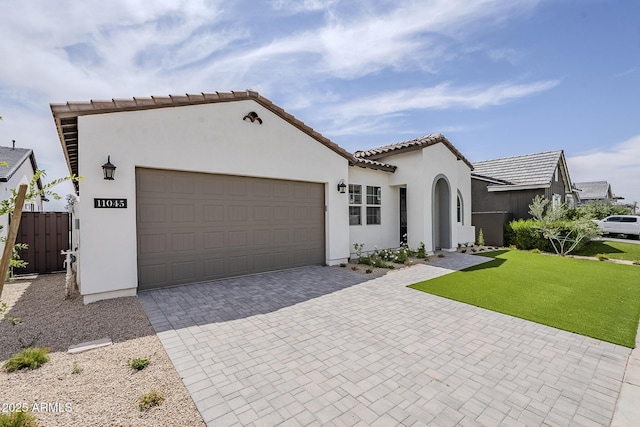 11045 N Hershey St, Surprise, AZ 85388 - mediterranean / spanish-style house featuring decorative driveway, an attached garage, stucco siding, a front lawn, and a tile roof