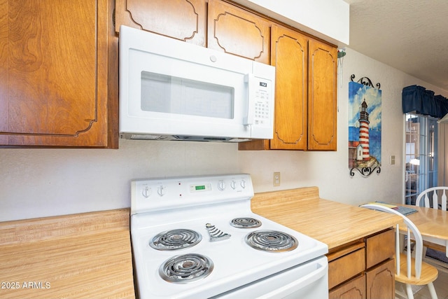 kitchen with light countertops, white appliances, and brown cabinetry