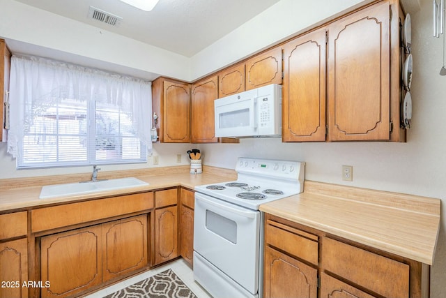 kitchen featuring sink, white appliances, and light tile patterned floors