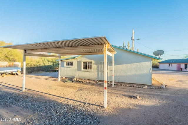 exterior space with a carport and stucco siding