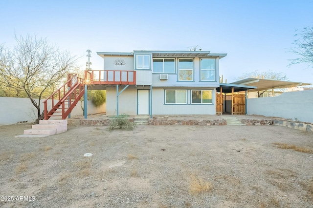 rear view of house featuring stairs and fence