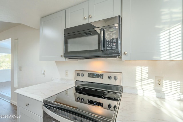 kitchen with white cabinetry, light stone countertops, and stainless steel electric range oven