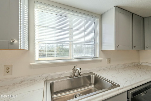 kitchen featuring dishwasher and a sink