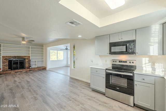 kitchen featuring light hardwood / wood-style floors, a fireplace, white cabinets, stainless steel electric stove, and ceiling fan