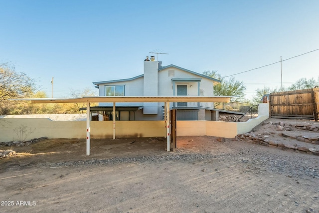 rear view of house with fence and a chimney