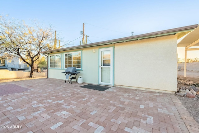 rear view of house featuring stucco siding and a patio