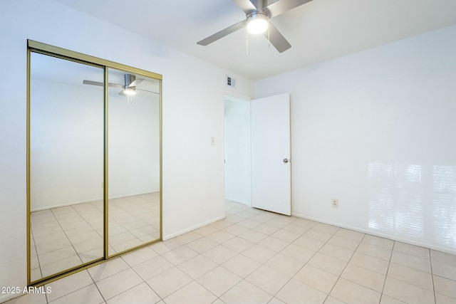 unfurnished bedroom featuring light tile patterned floors, ceiling fan, visible vents, and a closet