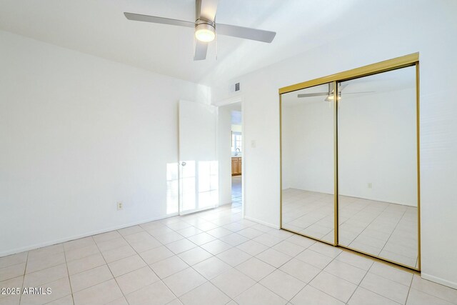 unfurnished bedroom featuring light tile patterned floors, ceiling fan, visible vents, and a closet