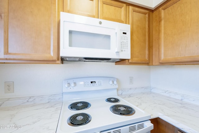 kitchen featuring white appliances and light stone countertops