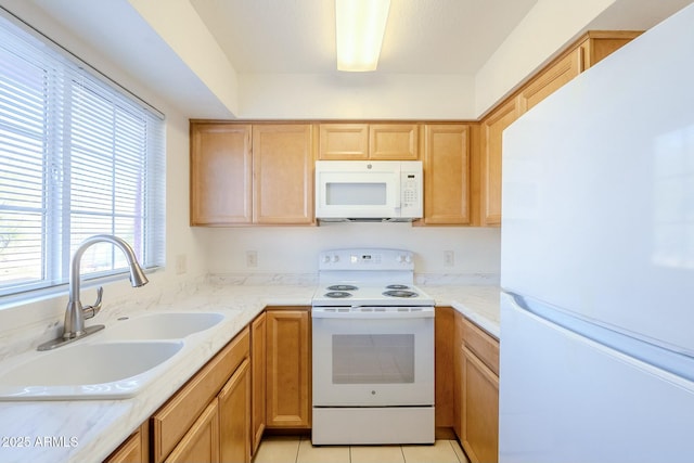 kitchen with sink, white appliances, plenty of natural light, and light tile patterned flooring