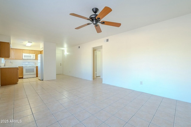 unfurnished living room featuring sink, light tile patterned flooring, and ceiling fan