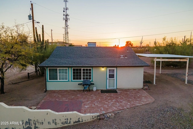 back of property featuring a shingled roof, a patio, and stucco siding