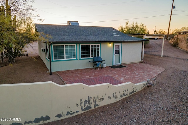 view of front of house with fence private yard, roof with shingles, a patio, and a chimney