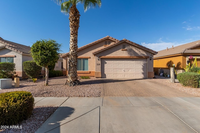 8714 W Heber Rd, Tolleson, AZ 85353 - view of front of home featuring stucco siding, an attached garage, and decorative driveway