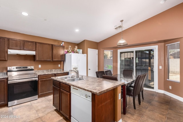 kitchen featuring pendant lighting, an island with sink, lofted ceiling, sink, and white appliances