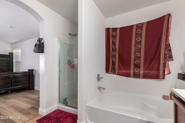 bathroom with shower with separate bathtub, hardwood / wood-style floors, and vanity