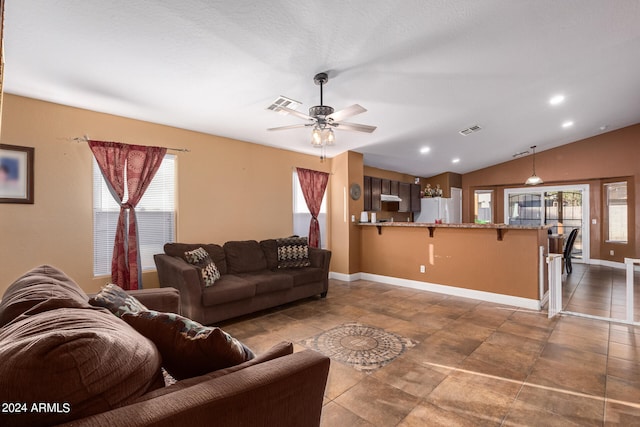 tiled living room with ceiling fan, lofted ceiling, and a wealth of natural light