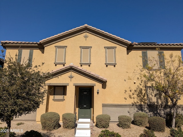 view of front of house featuring a tile roof and stucco siding