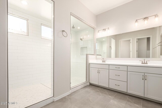 bathroom featuring tiled shower, tile patterned floors, and vanity