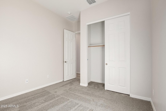 unfurnished bedroom with a closet and light colored carpet