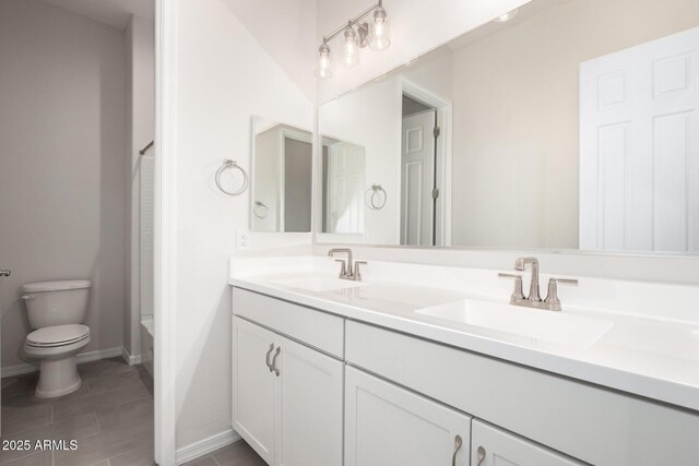 bathroom with toilet, vanity, and tile patterned floors